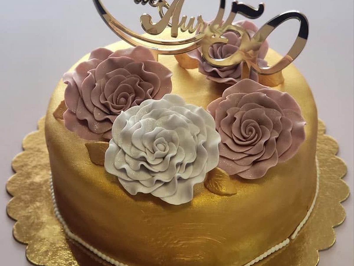 Tort aurit cu trandafiri modelați de mână, pentru nunta de aur