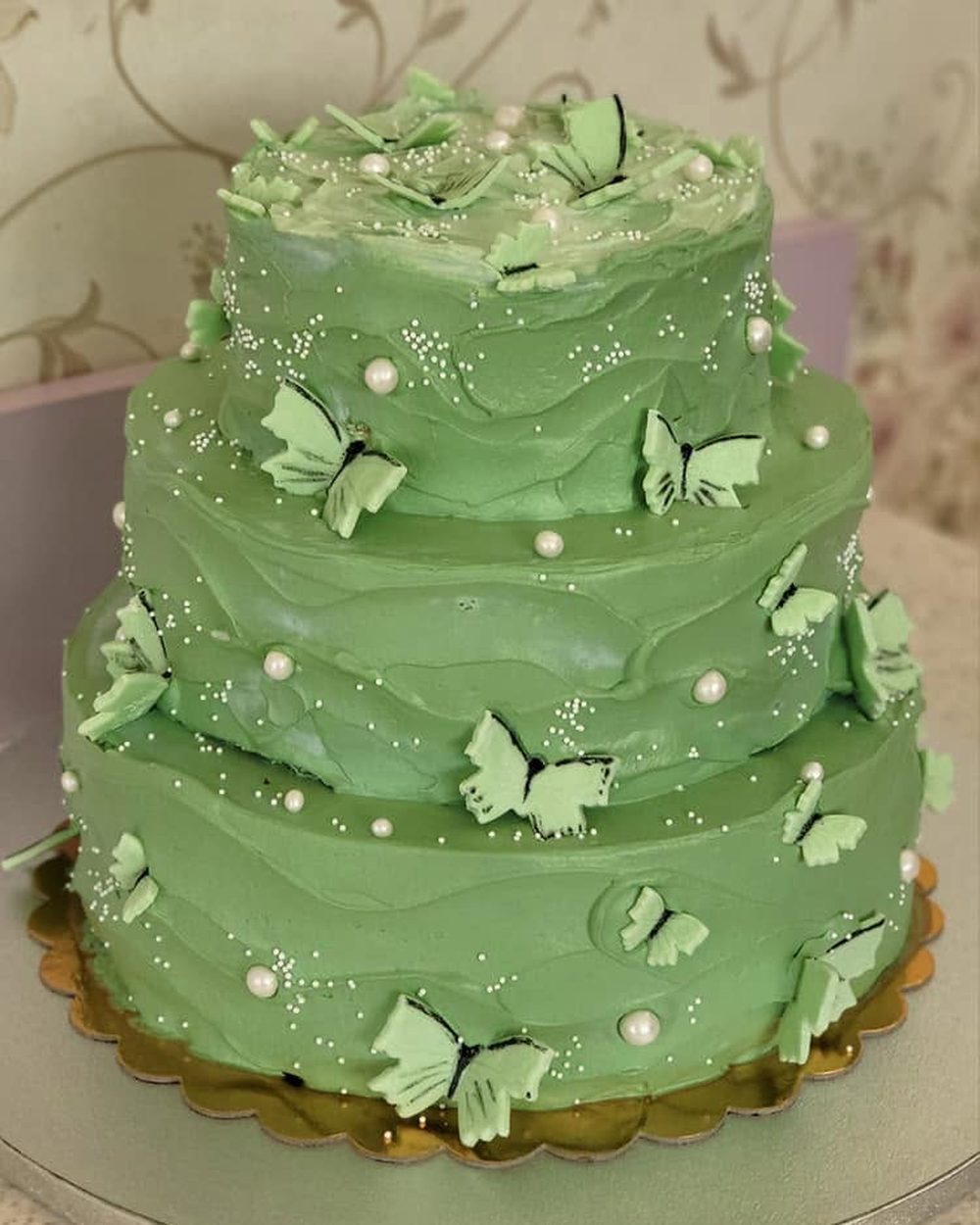 Tort cu trei etaje, cremă verde și fluturi de ciocolată albă